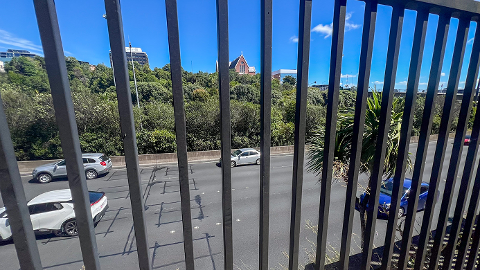 View of the motorway through a fence at Grafton Gully