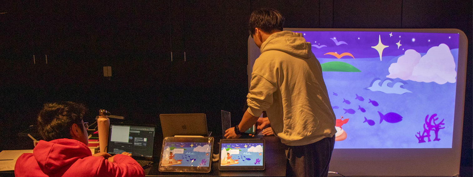 Team members collaborating on the Upright Rainbow interactive projector exhibition